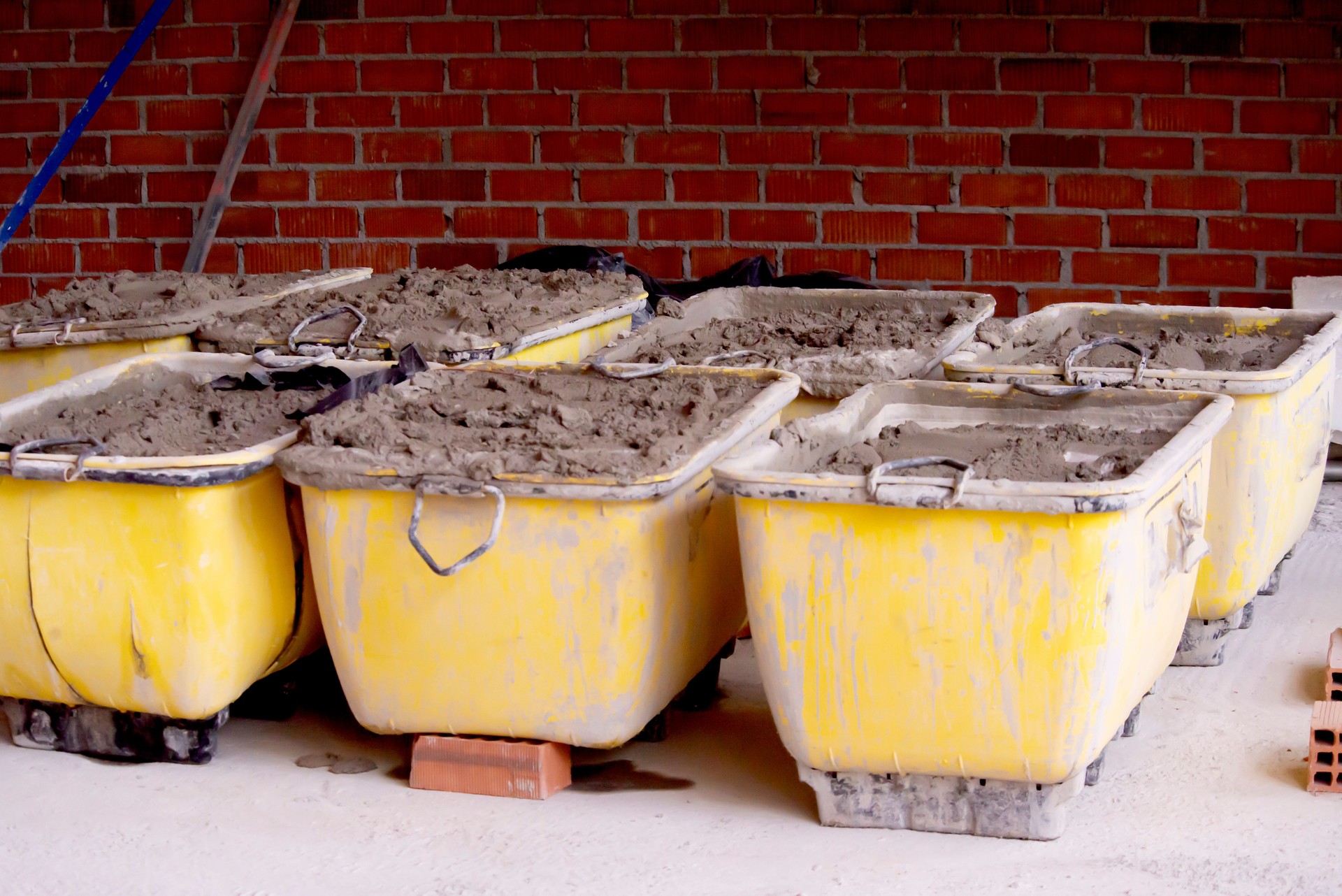 Ready-mix concrete in metal containers with holes for a lifting chain on the territory of a building