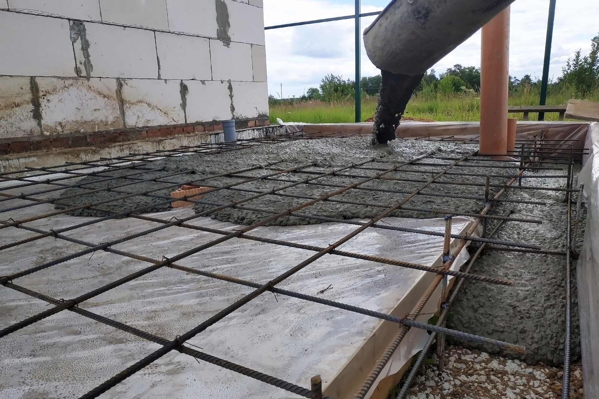 Pouring concrete after placing steel reinforcement to make a screed, the photo shows sewer pipes.